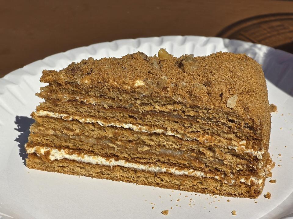 Кусок медовика с кремом между коржами